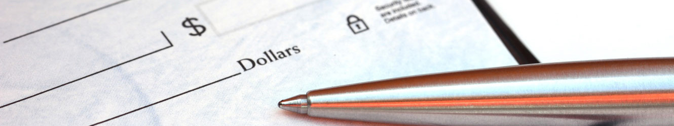 Close up of a metal pen sitting of top of a bank check.